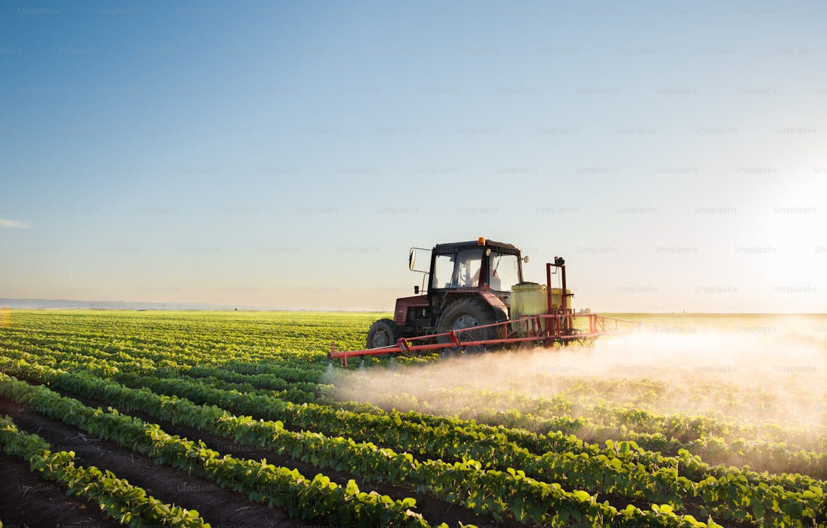Tractor spraying crops in field